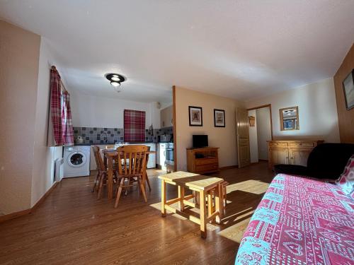 a living room with a table and a kitchen at Résidence Atrey Clés Blanches in La Tania