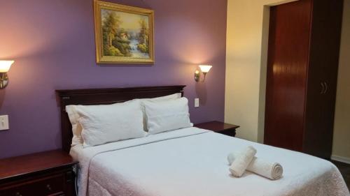 a hotel room with a bed with a pair of shoes on it at Villa D este in Kimberley