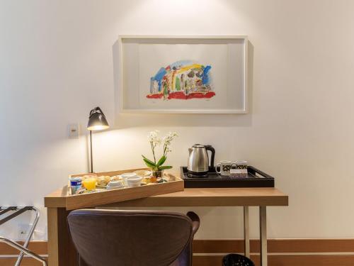 a room with a desk with a coffee maker on it at Athos Bulcão Hplus Executive in Brasilia