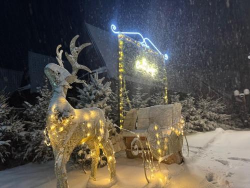 a statue of a reindeer and a sleigh in the snow at The Crown Lodge in Zlatibor