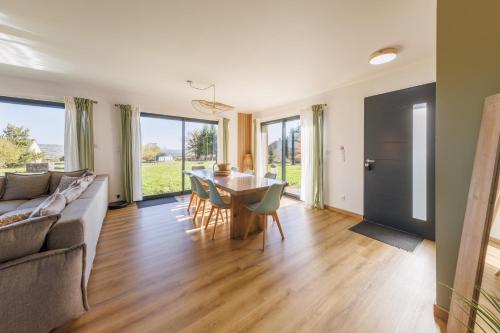 un salon avec un canapé, une table et des chaises dans l'établissement Les 4 Saisons des Violonges - Vue montagne, à Neussargues en Pinatelle