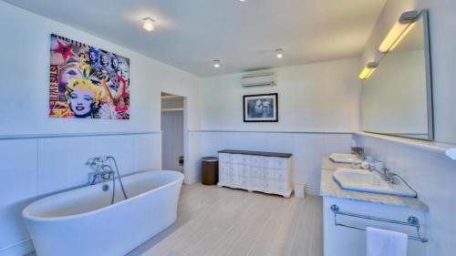 a bathroom with a large tub and a sink and a tub at Stunning 6BR Villa Near Longue Bay Beach in Baie Longue