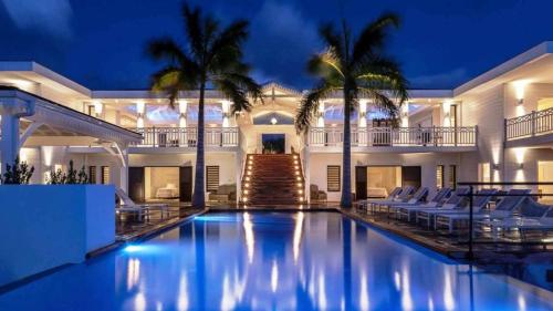 a villa with a swimming pool at night at Stunning 6BR Villa Near Longue Bay Beach in Baie Longue