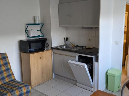 une petite cuisine avec un évier et un micro-ondes dans l'établissement Charmant studio 19m² pour 4 pers., accès direct pistes, proche commerces et activités, Orcières - FR-1-262-81, à Forest des Baniols