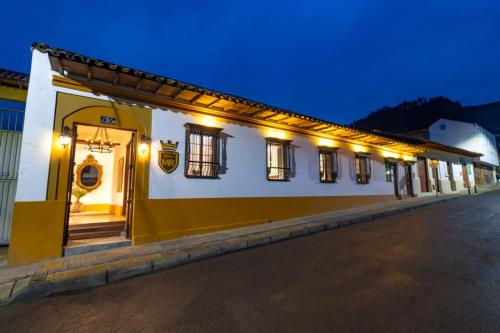 a yellow and white building with lights on it at Hotel Boutique MR in Zipaquirá
