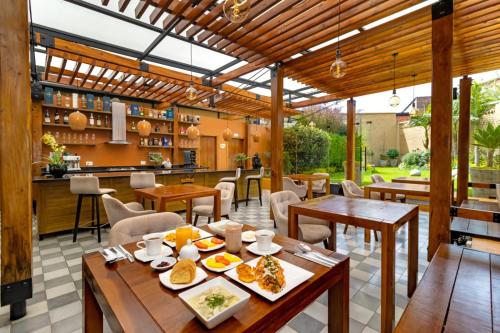 a patio with wooden tables and chairs and a kitchen at Hotel Boutique MR in Zipaquirá