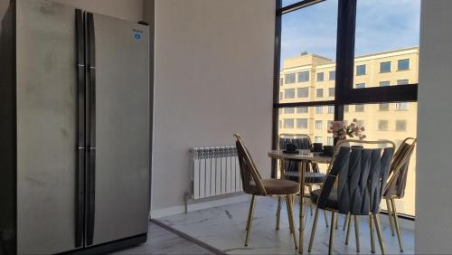 アクタウにあるПанорама комфортаのテーブルと椅子と窓のあるダイニングルーム