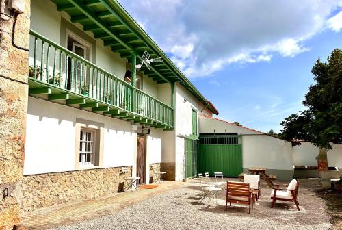 ein Gebäude mit einem begrünten Balkon und Stühlen in der Unterkunft Casona a 1km de la playa de Gerra in La Revilla