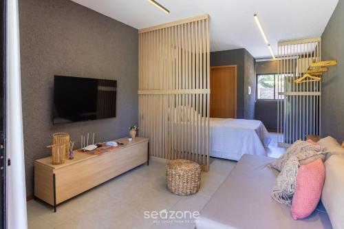 a bedroom with a bed and a tv in a room at Studio em Cond. c/ piscina próx. da praia CVKB0006 in São Miguel dos Milagres