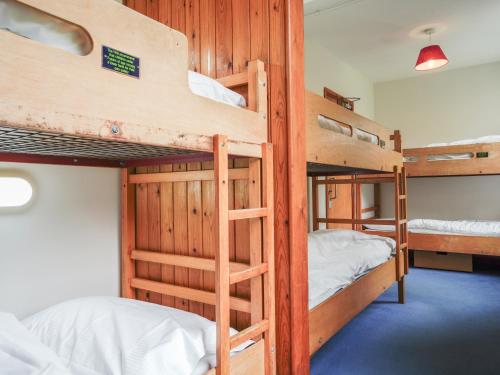 a room with four bunk beds in a cabin at YHA Borrowdale in Rosthwaite