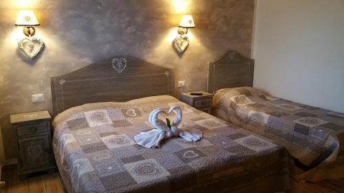 a bedroom with two beds with a swan on the bed at La Casa Delle Rondini in Roncoferraro