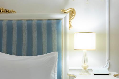 a bedroom with a bed and a lamp and a mirror at Ca' Bonfadini Historic Experience in Venice