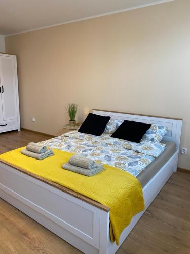 a bedroom with a large bed with a yellow blanket at City Lights Apartment in Barlinek