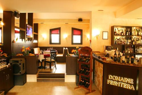 a restaurant with a bar and a dining room at Hotel Domaine Peshtera in Peshtera