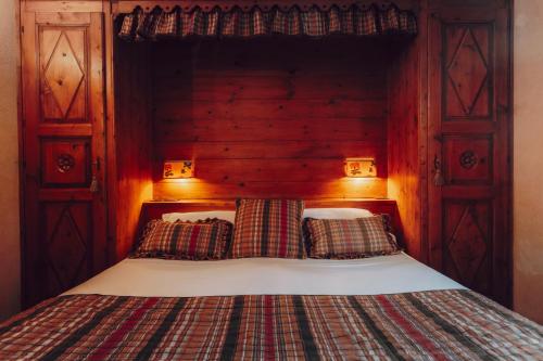 a bedroom with a bed with a wooden head board at Villa Novecento Romantic Hotel - Estella Hotel Collection & Experience in Courmayeur