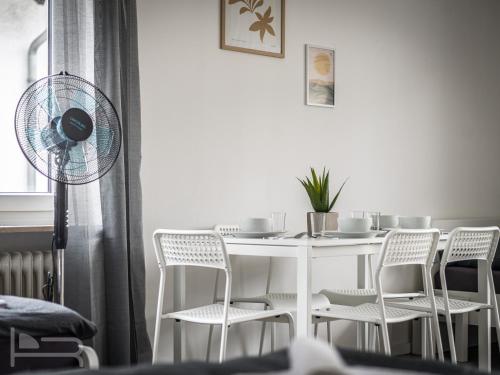 tavolo da pranzo bianco con sedie bianche e ventilatore di Voll ausgestattete Apartments mit Einzelbetten - Küche - WLAN - PKW-Parkplatz a Rödermark