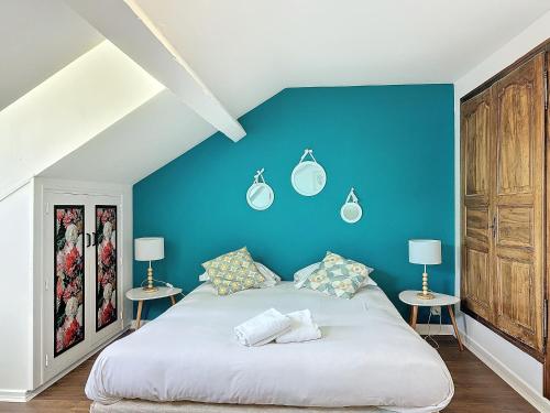 - une chambre dotée d'un mur bleu avec un lit et deux tables dans l'établissement Le Salignat Climatisé, Centre, Proche Thermes, à Vichy