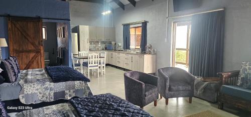 a living room with a couch and a kitchen at Valley Bushveld Country Lodge in Addo