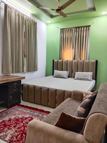 un dormitorio con una cama y un sofá en Gokul Niwas Udaipur Home Stay, en Udaipur