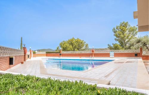 una piscina con una fuente y una pared de ladrillo en Amazing Apartment In Sant Pere De Ribes, en Sant Pere de Ribes