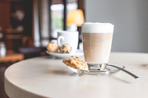 a cup of coffee and a plate of donuts on a table at PLAZA INN Recklinghausen in Recklinghausen