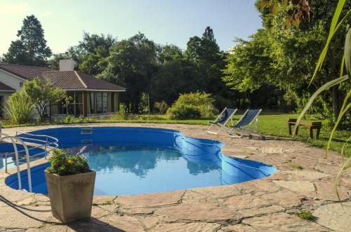 a swimming pool with chairs and a house at Quebrada Mansa in Nono