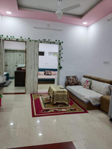 una sala de estar con un sofá y una alfombra en Gokul Niwas Udaipur Home Stay, en Udaipur