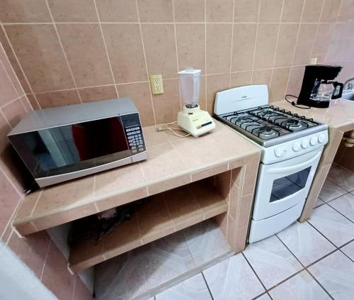 a kitchen with a microwave oven and a stove at Departamento Renata Huatulco in Santa Cruz Huatulco