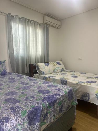 una camera da letto con due letti e una finestra di Casa Forte Refúgio a Bezerros