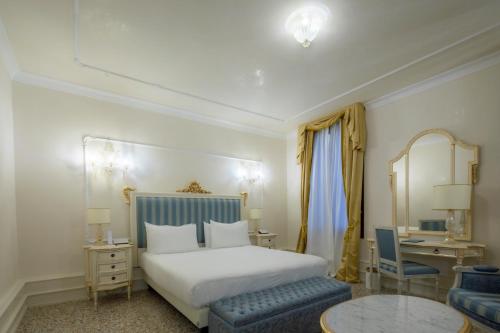 a bedroom with a bed and a table and a chair at Ca' Bonfadini Historic Experience in Venice