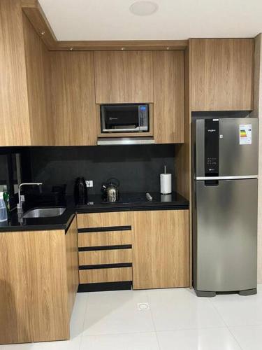 a kitchen with a stainless steel refrigerator and a microwave at Equipetrol Edificio Tuareg 110 in Santa Cruz de la Sierra