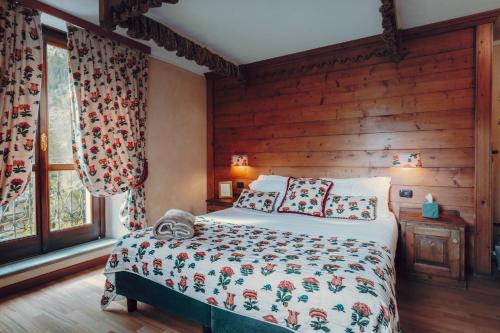 a bedroom with a bed and a wooden wall at Villa Novecento Romantic Hotel - Estella Hotel Collection & Experience in Courmayeur