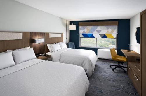 a hotel room with two beds and a desk and a window at Holiday Inn Express & Suites Stevensville - Benton Harbor by IHG in Stevensville