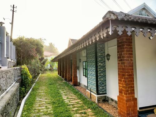 a house with a brick and green trim at Thomaskuttys Farmhouse Homestay in Rānī