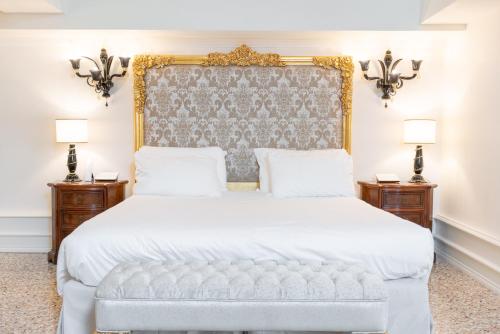 a bedroom with a white bed with a large headboard at Ca' Bonfadini Historic Experience in Venice