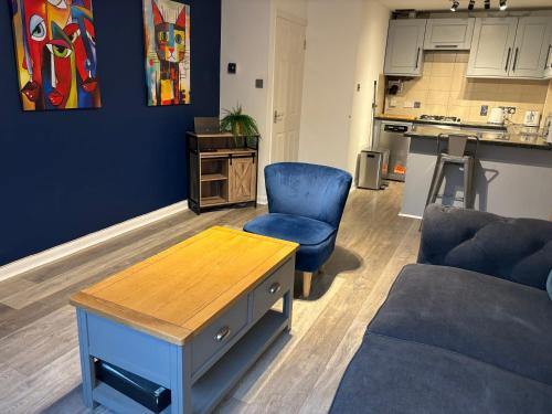 a living room with a couch and a chair and a table at Superb Central Flat, 3 mins to Station and Parking in Staines upon Thames