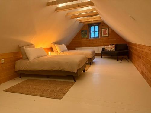 a attic bedroom with two beds and a couch at Erve Soebringe in Ansen