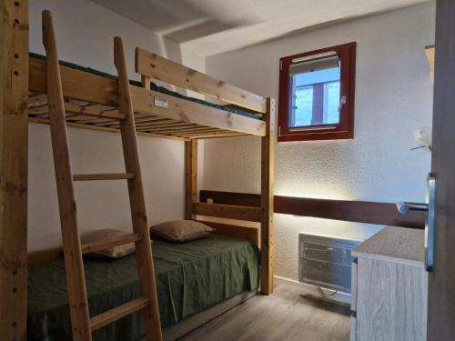 une chambre avec deux lits superposés et une fenêtre dans l'établissement Charmant 2 pièces, 4 pers, proche télécabine, balcon sud, Arc 1800 - FR-1-411-889, à Bourg-Saint-Maurice
