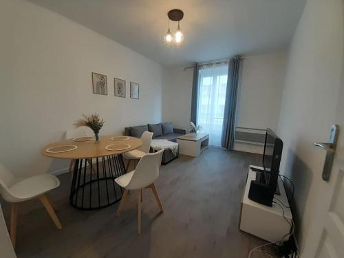 un salon avec une table et un canapé dans l'établissement Appartement à 10min du Stade de France, à Saint-Denis