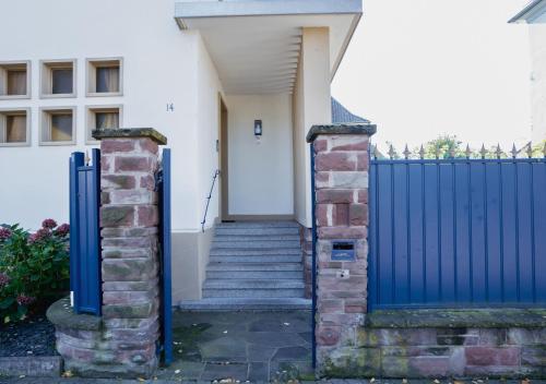 a blue gate in front of a house with stairs at Charmant appartement avec terrasse dans villa in Strasbourg