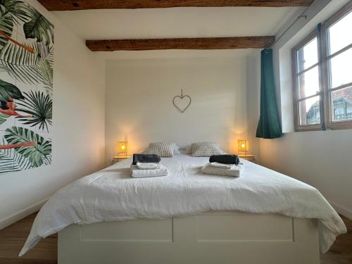 a bedroom with a large white bed with two lamps at Les 7 Prunes - Demeure Alsacienne d'Exception in Zellwiller