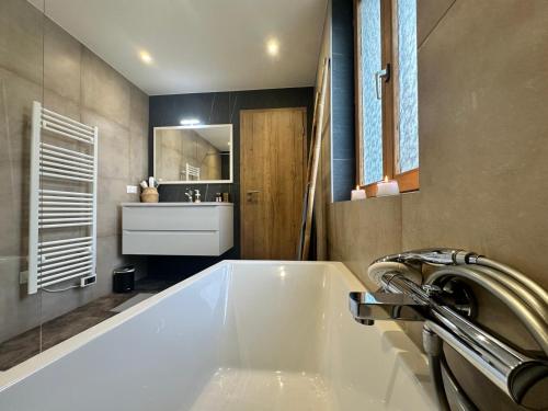 a bathroom with a large white tub and a sink at Les 7 Prunes - Demeure Alsacienne d'Exception in Zellwiller