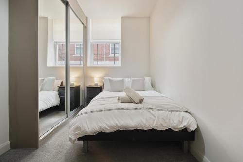 ein Schlafzimmer mit einem großen Bett mit Spiegel in der Unterkunft Vibrant 1 Bed Apartment, FREE Parking, North Church St, Sheffield City Centre - Hosted by Stay Host Save in Midland