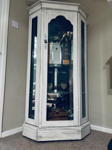 a white cabinet with glass doors in a room at Modern Lancashire stay with private Hot-tub in Skelmersdale