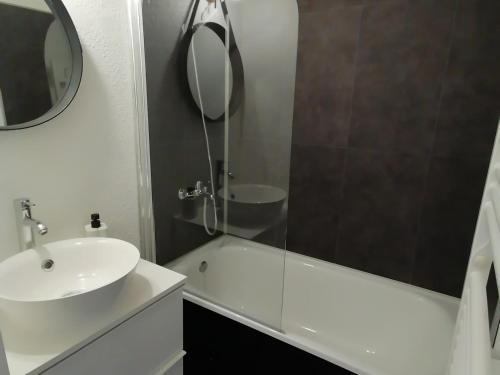 une salle de bain blanche avec un lavabo et un miroir dans l'établissement Charmant studio ski aux pieds avec terrasse et parking - FR-1-181-2847, à Aime La Plagne