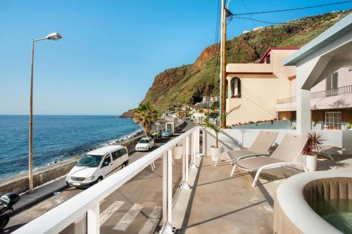 a white van parked on a balcony next to the ocean at Sunset house in Paul do Mar