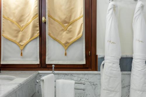 a bathroom with a sink and a window with curtains at Ca' Bonfadini Historic Experience in Venice