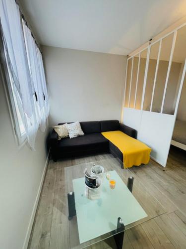 un salon avec un canapé et une table dans l'établissement Le Geneslay - Parking Privée, au Mans