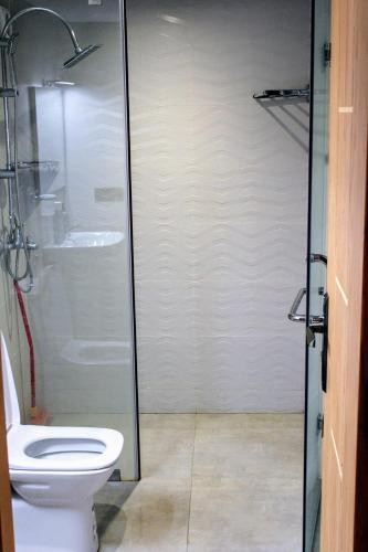 a bathroom with a toilet and a glass shower at شقق الاسد افران in Ifrane