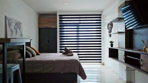 a bedroom with a bed and a large window at Atardecer Sur Belgrano in Ushuaia